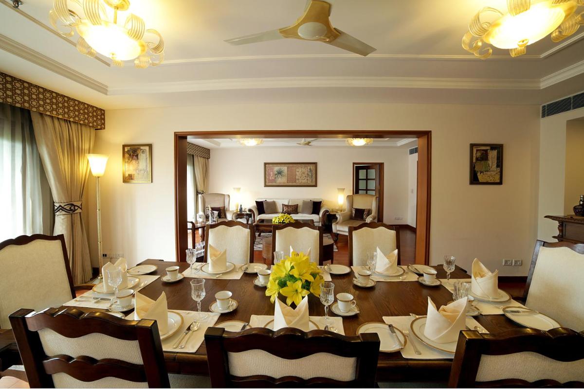 a dining room with a wooden table with chairs at Jaypee Palace Hotel in Agra