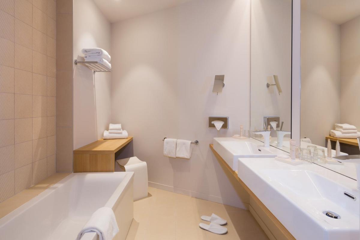 une salle de bain avec deux lavabos et une baignoire et des toilettes dans l'établissement Best Western Plus Hotel Divona Cahors, à Cahors
