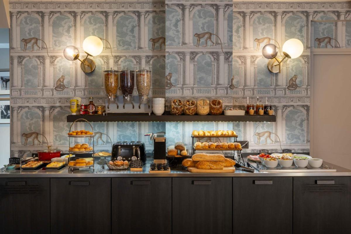 un buffet avec différents types de pains et de pâtisseries dans l'établissement Lyric Hotel Paris Opera, à Paris