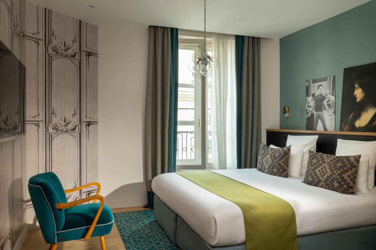 une chambre d'hôtel avec un lit et une chaise dans l'établissement Lyric Hotel Paris Opera, à Paris