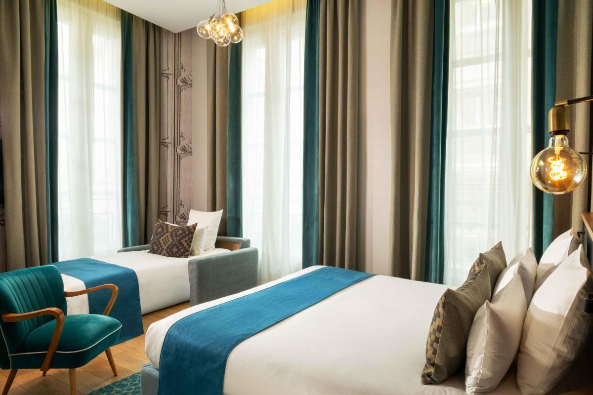 Un ou plusieurs lits dans un hébergement de l'établissement Lyric Hotel Paris Opera