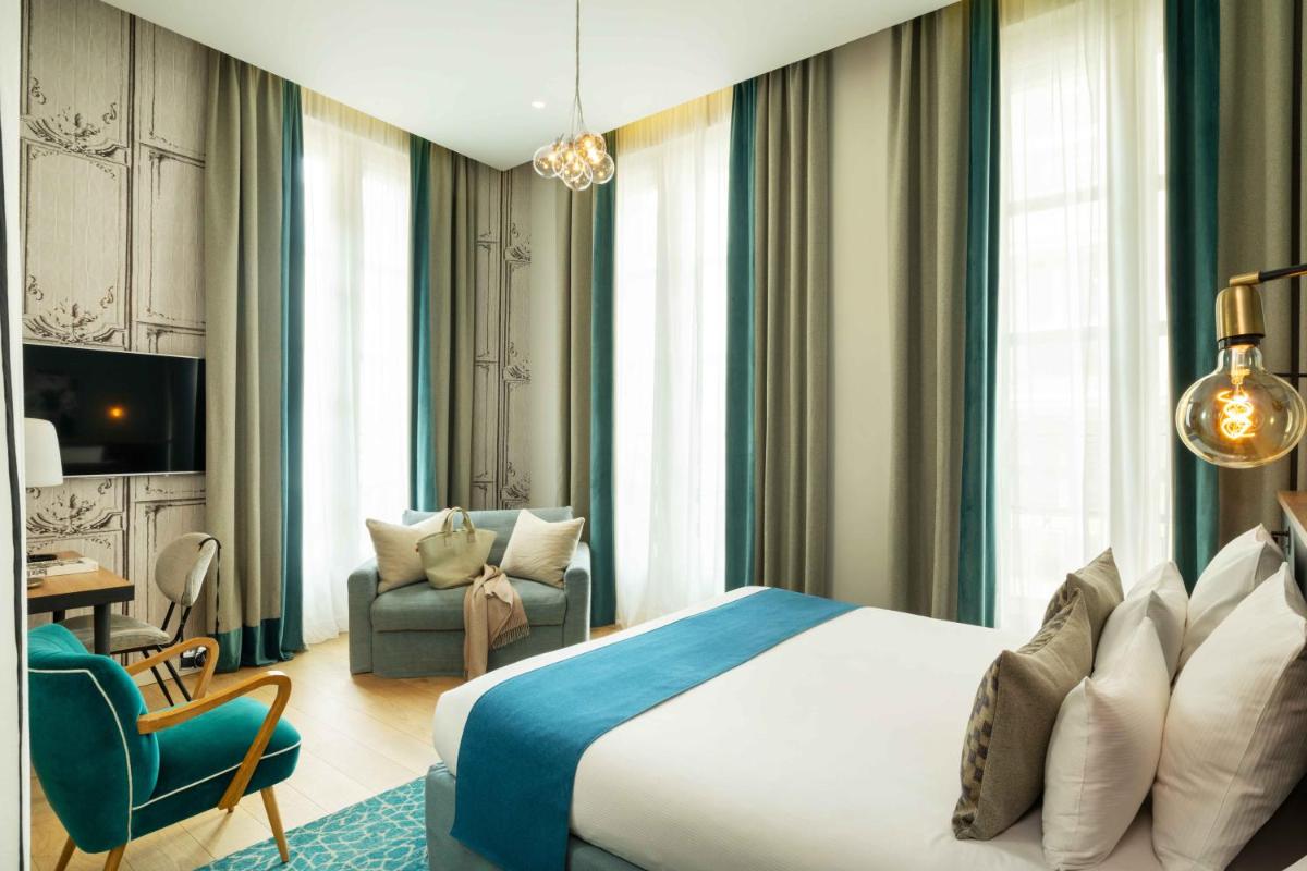 une chambre d'hôtel avec un lit et une chaise dans l'établissement Lyric Hotel Paris Opera, à Paris 37 autres photos