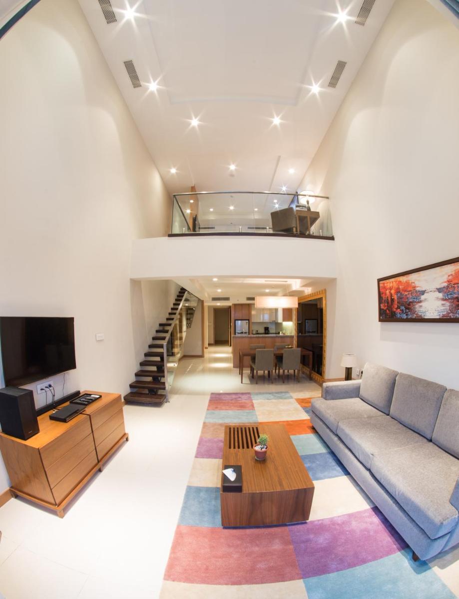 a living room with a couch and a tv at Oakwood Residence Kapil Hyderabad in Hyderabad