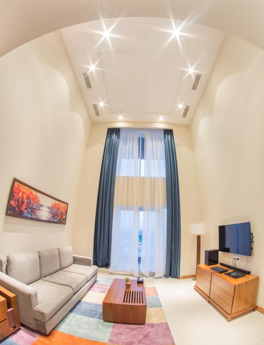 a living room with a couch and a tv at Oakwood Residence Kapil Hyderabad in Hyderabad
