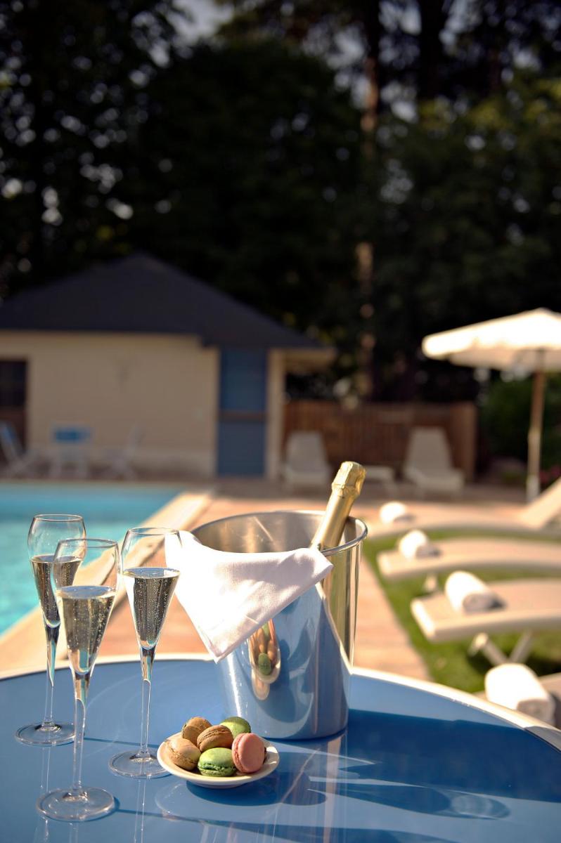 - une table avec 2 verres et une bouteille de vin dans l'établissement Logis Le Parc Hotel & Spa, à Château-Gontier