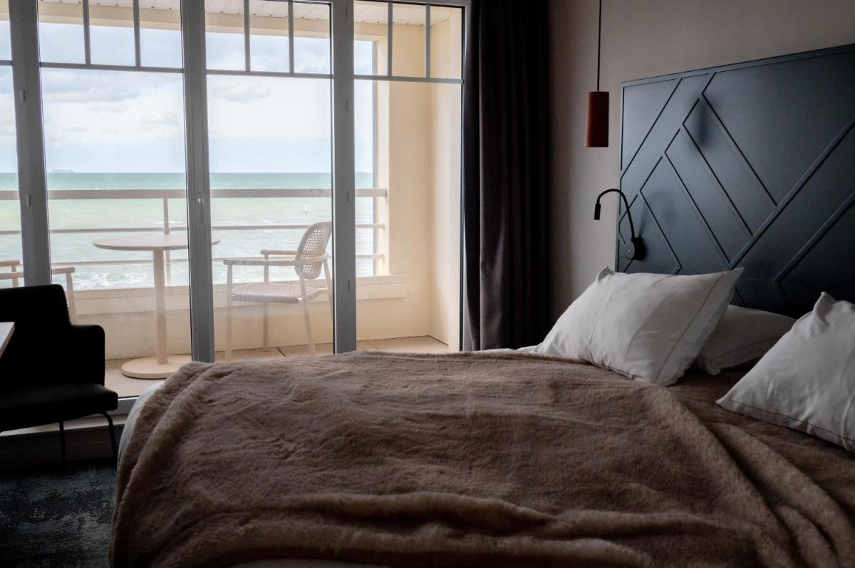Un ou plusieurs lits dans un hébergement de l'établissement Hotel Atlantic