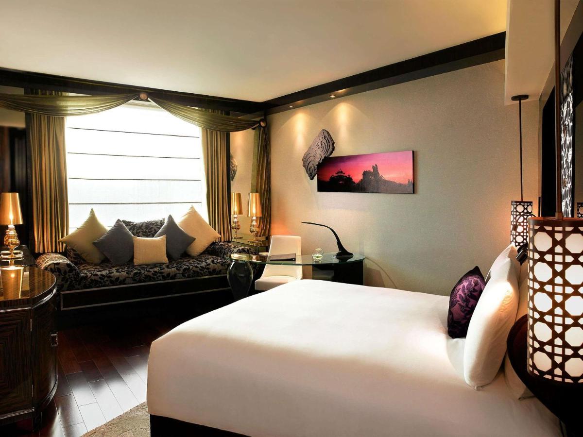 a hotel room with a bed and a couch at Sofitel Mumbai BKC in Mumbai