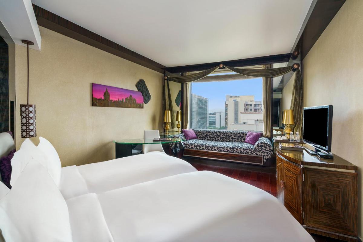 a hotel room with two beds and a television at Sofitel Mumbai BKC in Mumbai