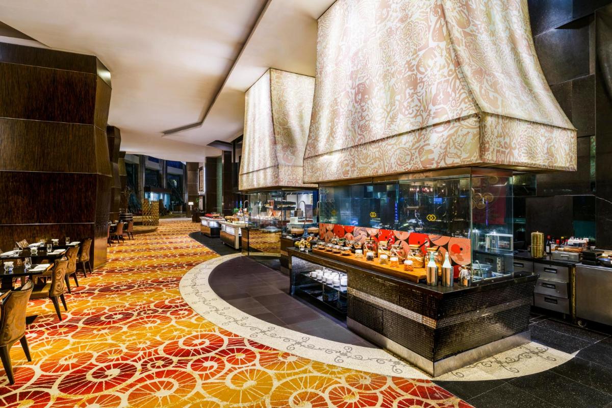 a restaurant with a large aquarium in the middle of a room at Sofitel Mumbai BKC in Mumbai