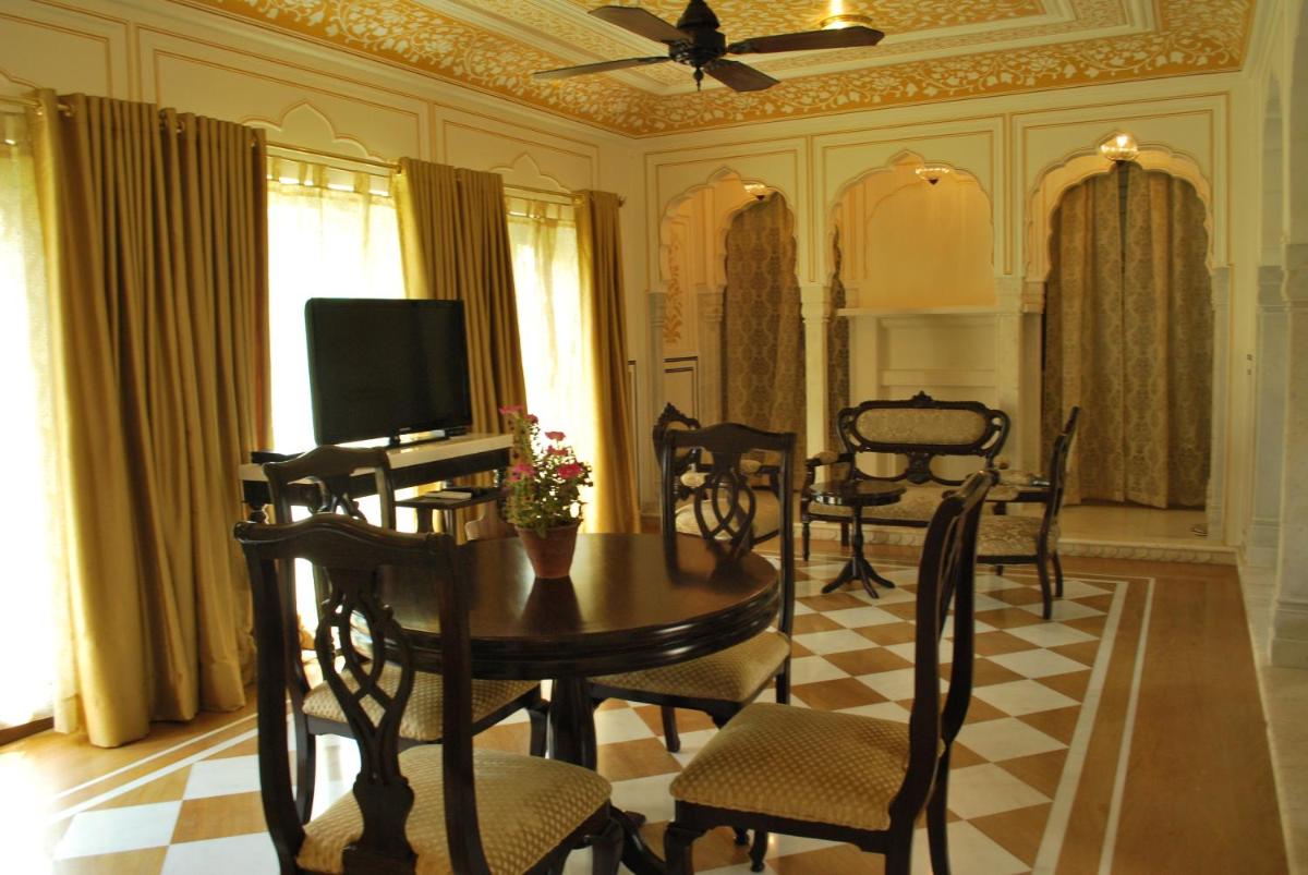 a dining room with a table and chairs and a television at Royal Heritage Haveli - By Leisure Hotels in Jaipur