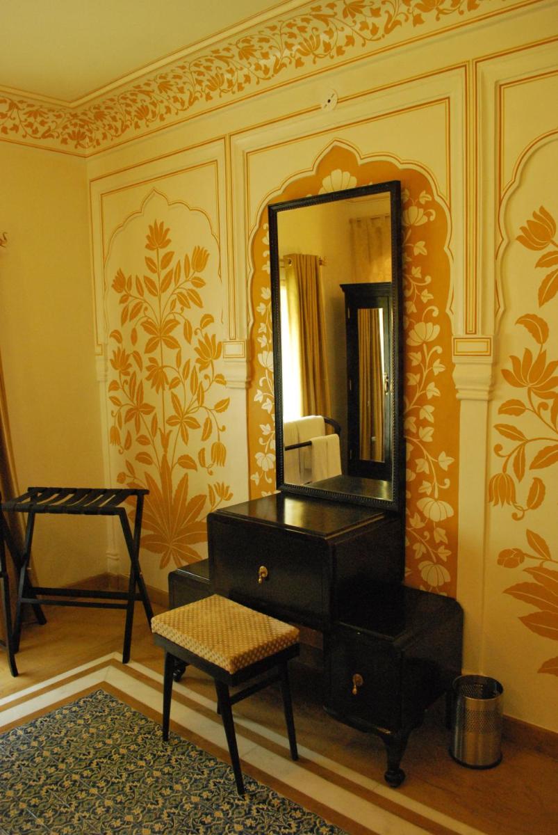 a room with a mirror and a dresser and a stool at Royal Heritage Haveli - By Leisure Hotels in Jaipur