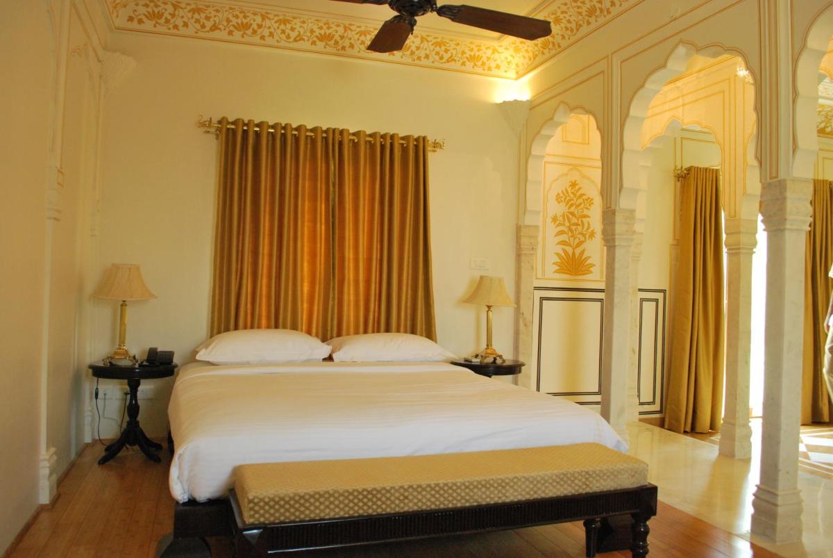 a bedroom with a large white bed with a ceiling at Royal Heritage Haveli - By Leisure Hotels in Jaipur