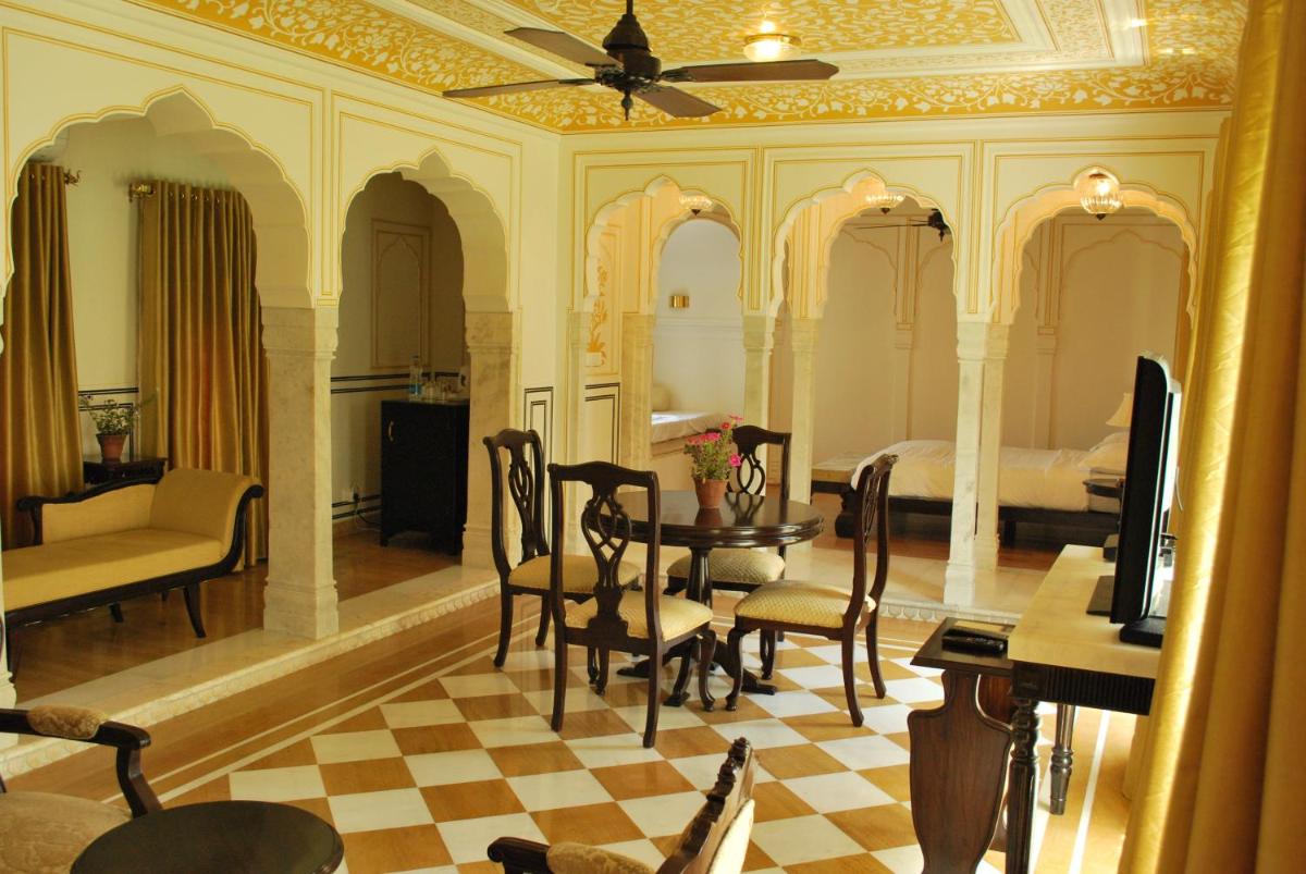 a bedroom with a bed and a table and chairs at Royal Heritage Haveli - By Leisure Hotels in Jaipur