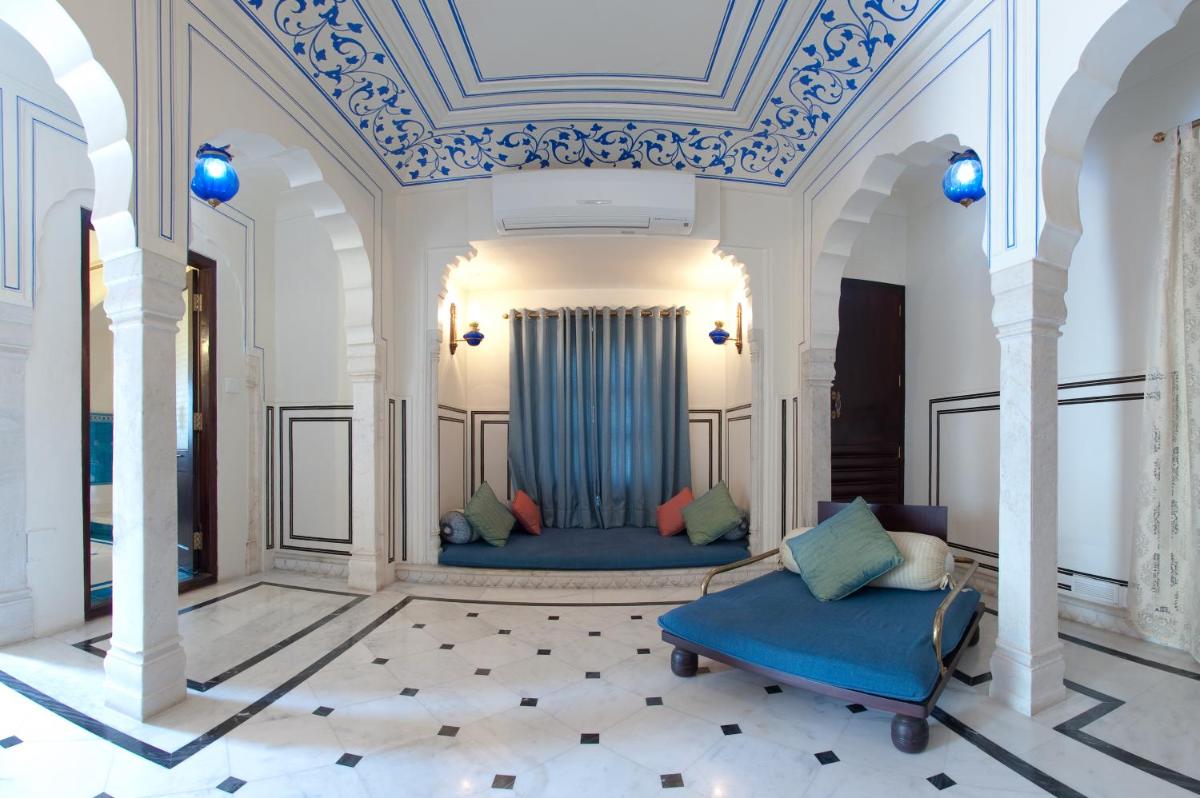 a living room with two blue couches and a ceiling at Royal Heritage Haveli - By Leisure Hotels in Jaipur