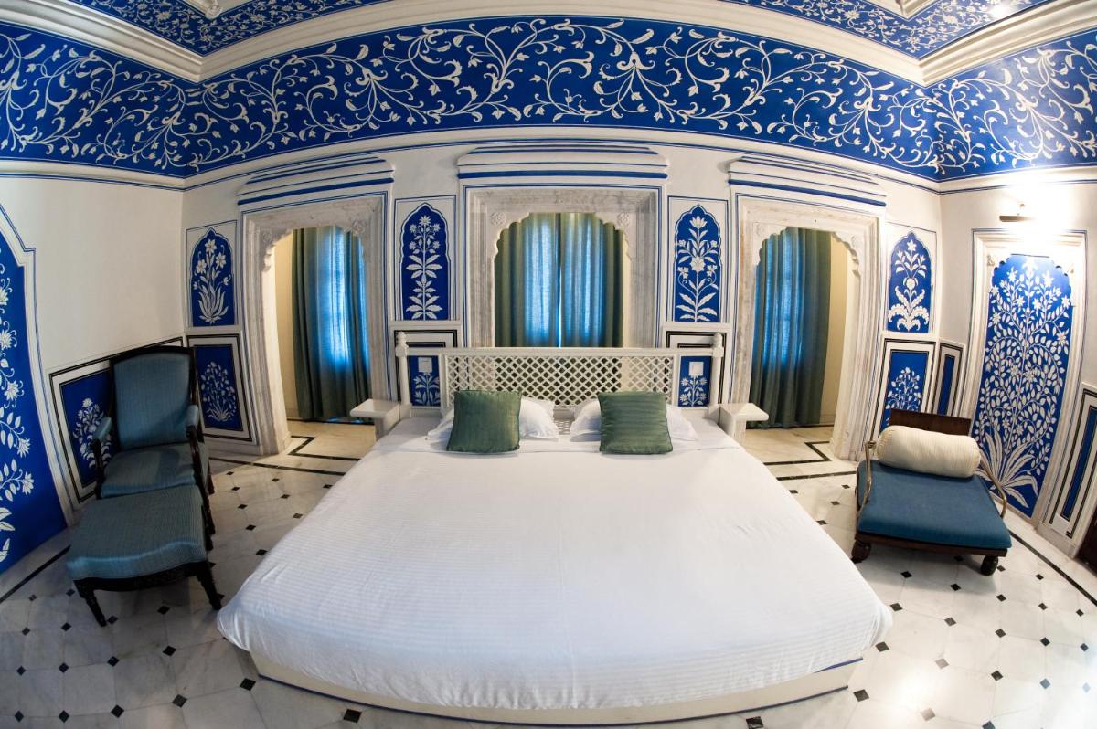 a blue and white bedroom with a bed and two chairs at Royal Heritage Haveli - By Leisure Hotels in Jaipur