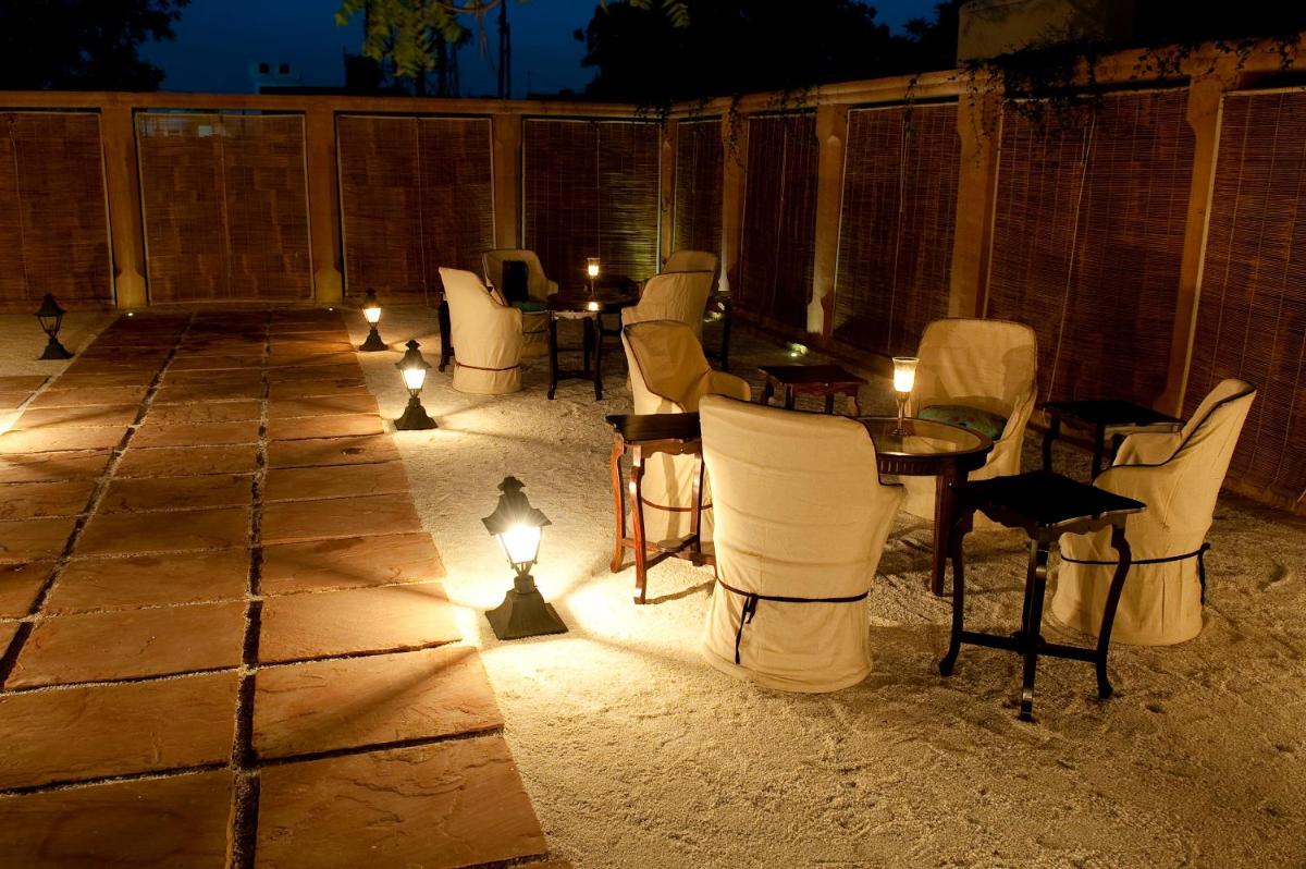 a patio with chairs and tables and lights at night at Royal Heritage Haveli - By Leisure Hotels in Jaipur