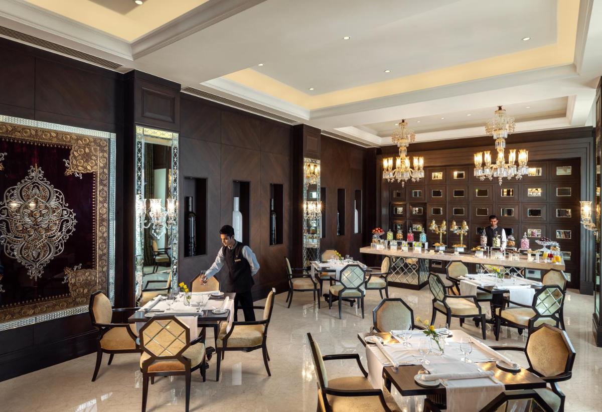 Un restaurante o sitio para comer en The Leela Palace Chennai
