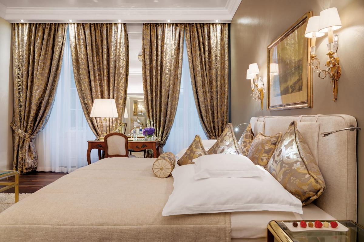 ein Schlafzimmer mit einem großen Bett und Kissen in der Unterkunft Hotel Europäischer Hof Heidelberg, Bestes Hotel Deutschlands in historischer Architektur in Heidelberg