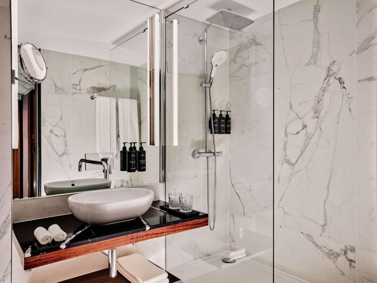 ein Badezimmer mit Waschbecken und Dusche in der Unterkunft Radisson Collection Hotel, Berlin in Berlin ein Badezimmer mit Waschbecken und Dusche in der Unterkunft Radisson Collection Hotel, Berlin in Berlin