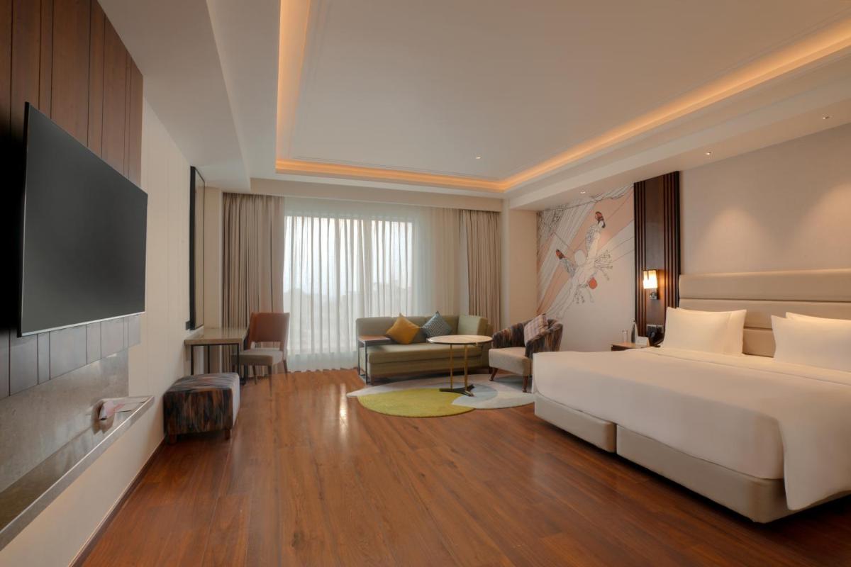 a hotel room with a bed and a television at Hyatt Centric Rajpur Road Dehradun in Dehradun