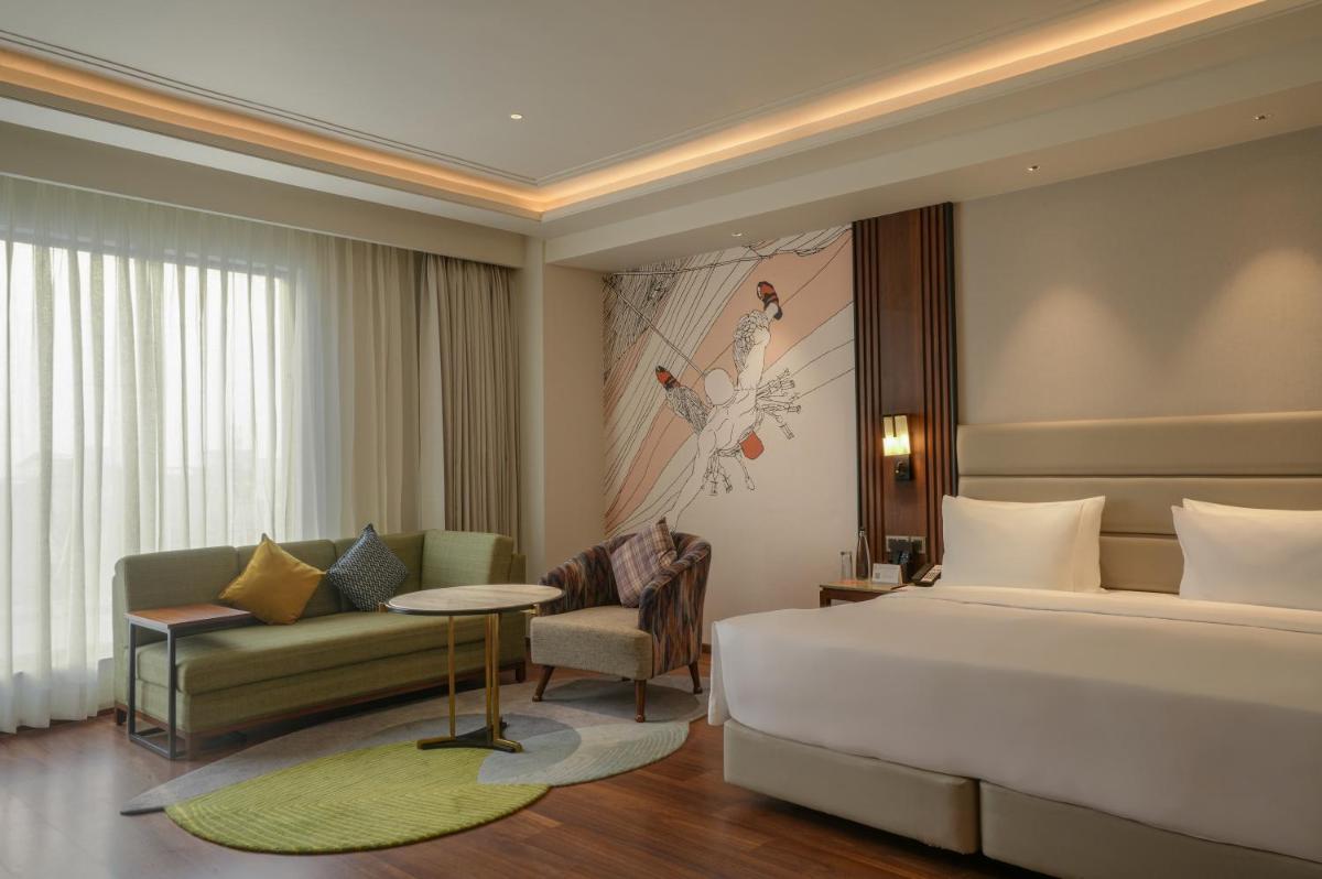 a hotel room with a bed and a couch at Hyatt Centric Rajpur Road Dehradun in Dehradun