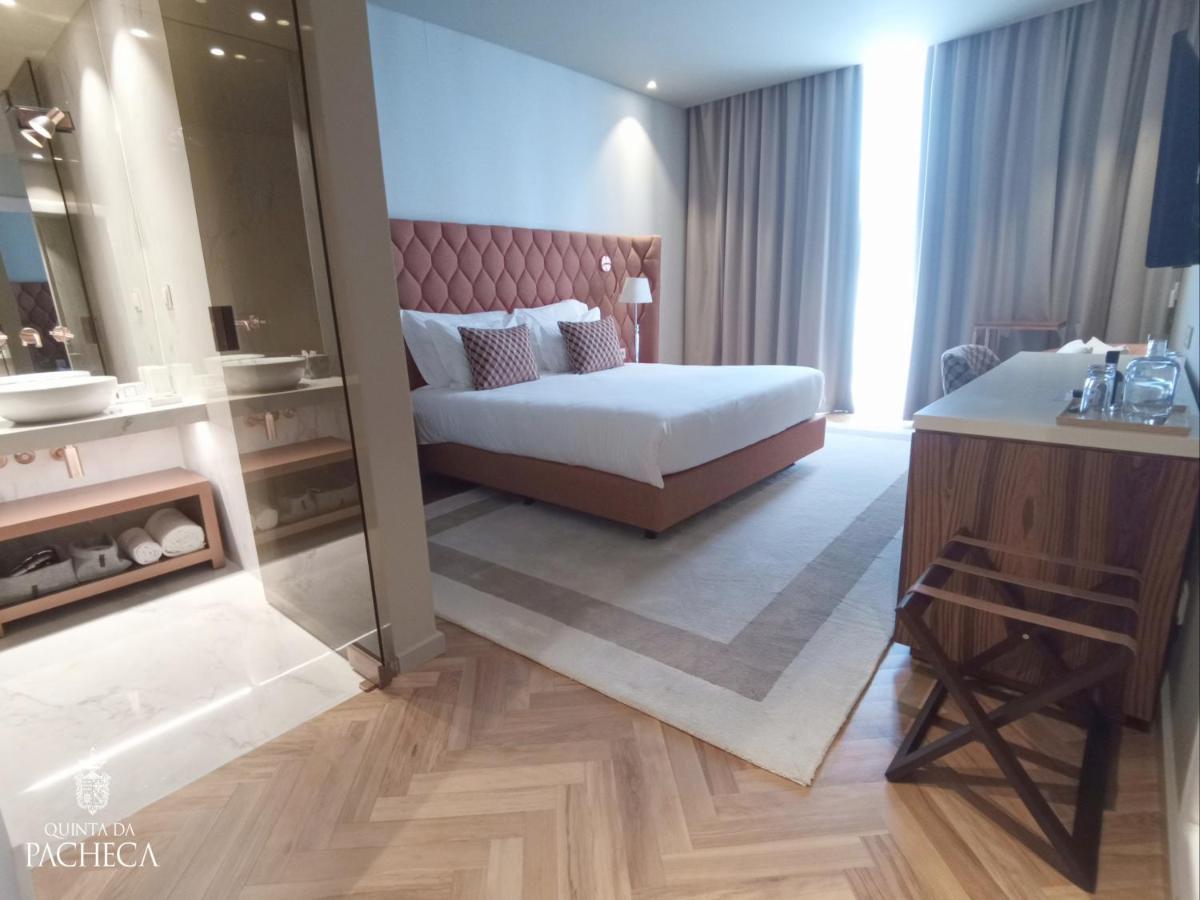 um quarto de hotel com uma cama e um espelho grande em Pacheca The Wine House Hotel e Spa - Quinta da Pacheca em Lamego