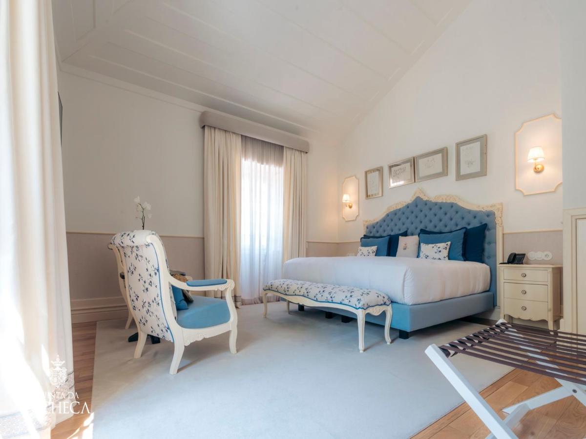 um quarto com uma cama azul e uma cadeira em Pacheca The Wine House Hotel e Spa - Quinta da Pacheca em Lamego mais 82 fotografias