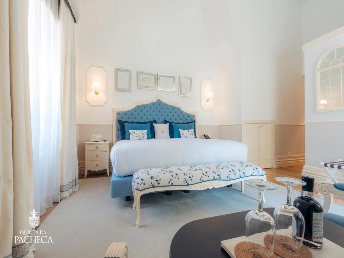 um quarto com uma cama azul e uma mesa em Pacheca The Wine House Hotel e Spa - Quinta da Pacheca em Lamego