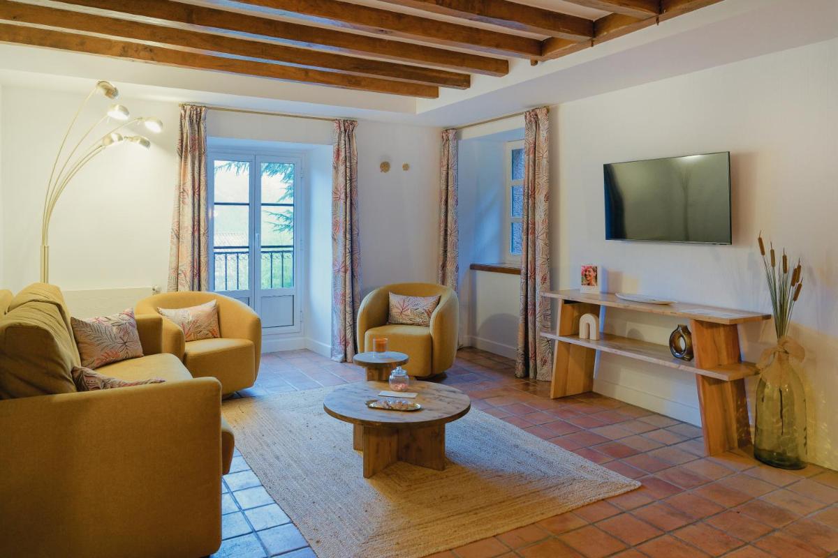 un salon avec un canapé, des fauteuils et une télévision dans l'établissement Le Domaine de Falgos Golf & Spa, à Saint-Laurent-de-Cerdans
