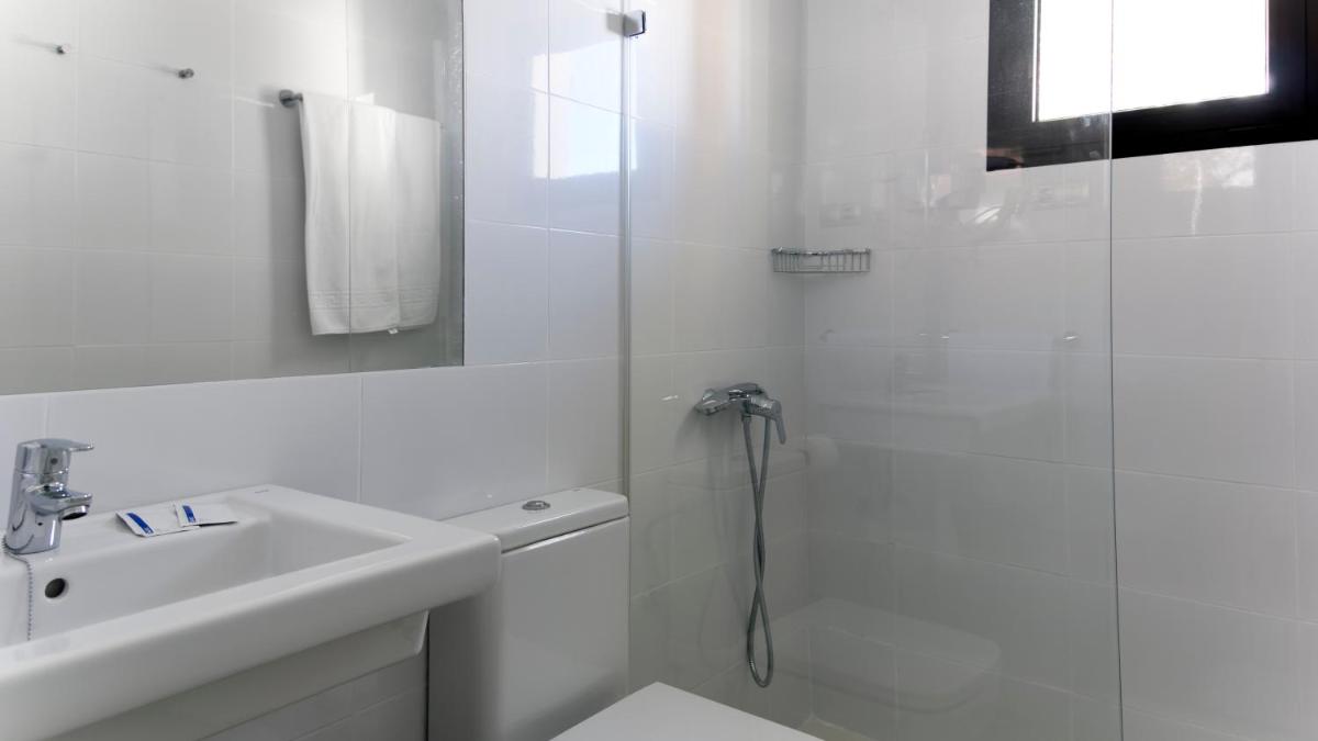 Un baño blanco con ducha y lavabo. en FBC Fortuny Resort - Adults Only, en Maspalomas