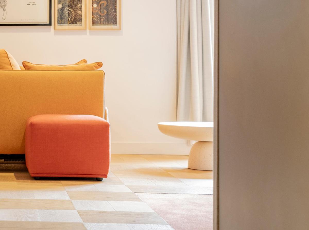 une valise rouge posée dans un salon dans l'établissement Hôtel Pilgrim, à Paris