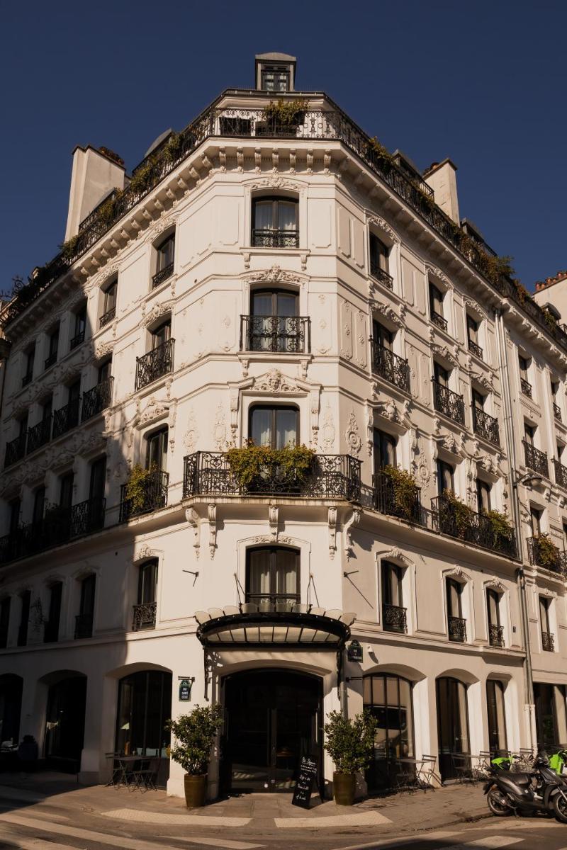 un bâtiment blanc avec des plantes sur sa façade dans l'établissement Hotel de Nell, à Paris