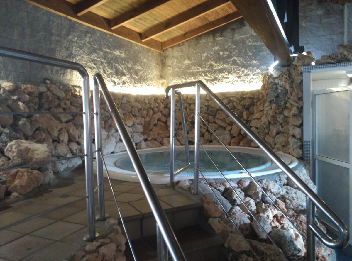 Un jacuzzi en una habitación con una pared de piedra. en Hotel Palacio de Oñate, en Guadix