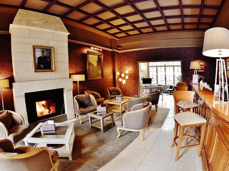 un salon avec cheminée et un salon avec chaises dans l'établissement Domaine de Joinville & Spa, à Eu