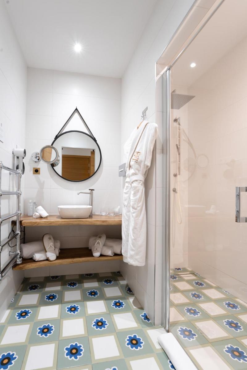 une salle de bains avec douche, lavabo et miroir dans l'établissement Hôtel Le Saint Remy & Spa, à Saint-Rémy-de-Provence