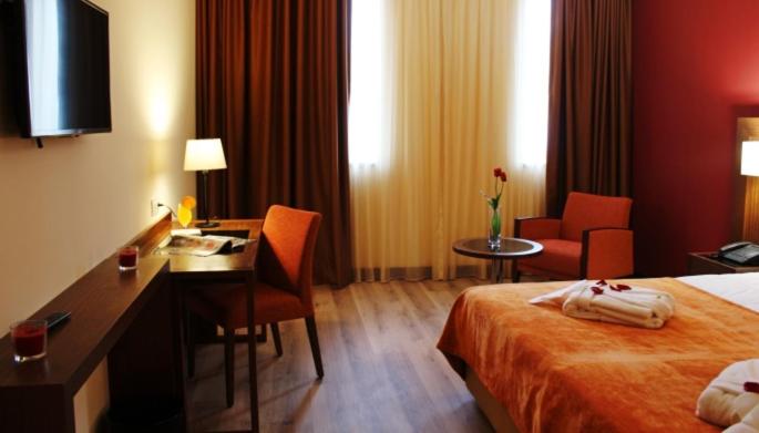 um quarto de hotel com uma cama, uma escrivaninha e uma escrivaninha em Palace Hotel Astúrias & Spa em Carvalhal mais 19 fotografias