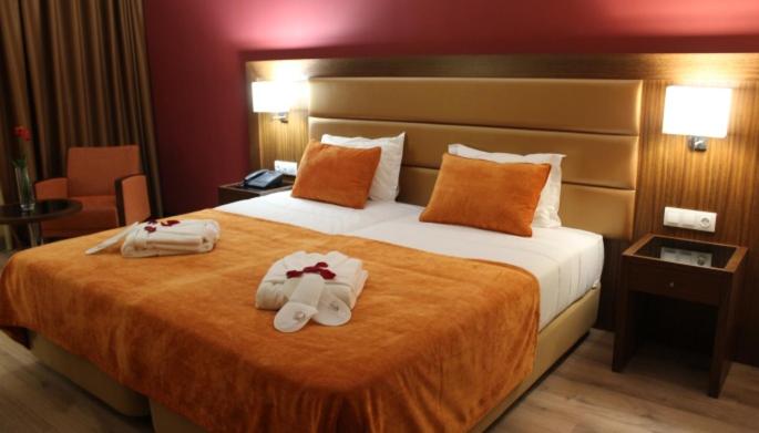 um quarto de hotel com uma cama com toalhas em Palace Hotel Astúrias & Spa em Carvalhal