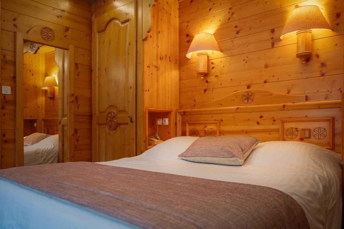 Un ou plusieurs lits dans un hébergement de l'établissement Chalet-Hôtel Neige et Roc, The Originals Relais