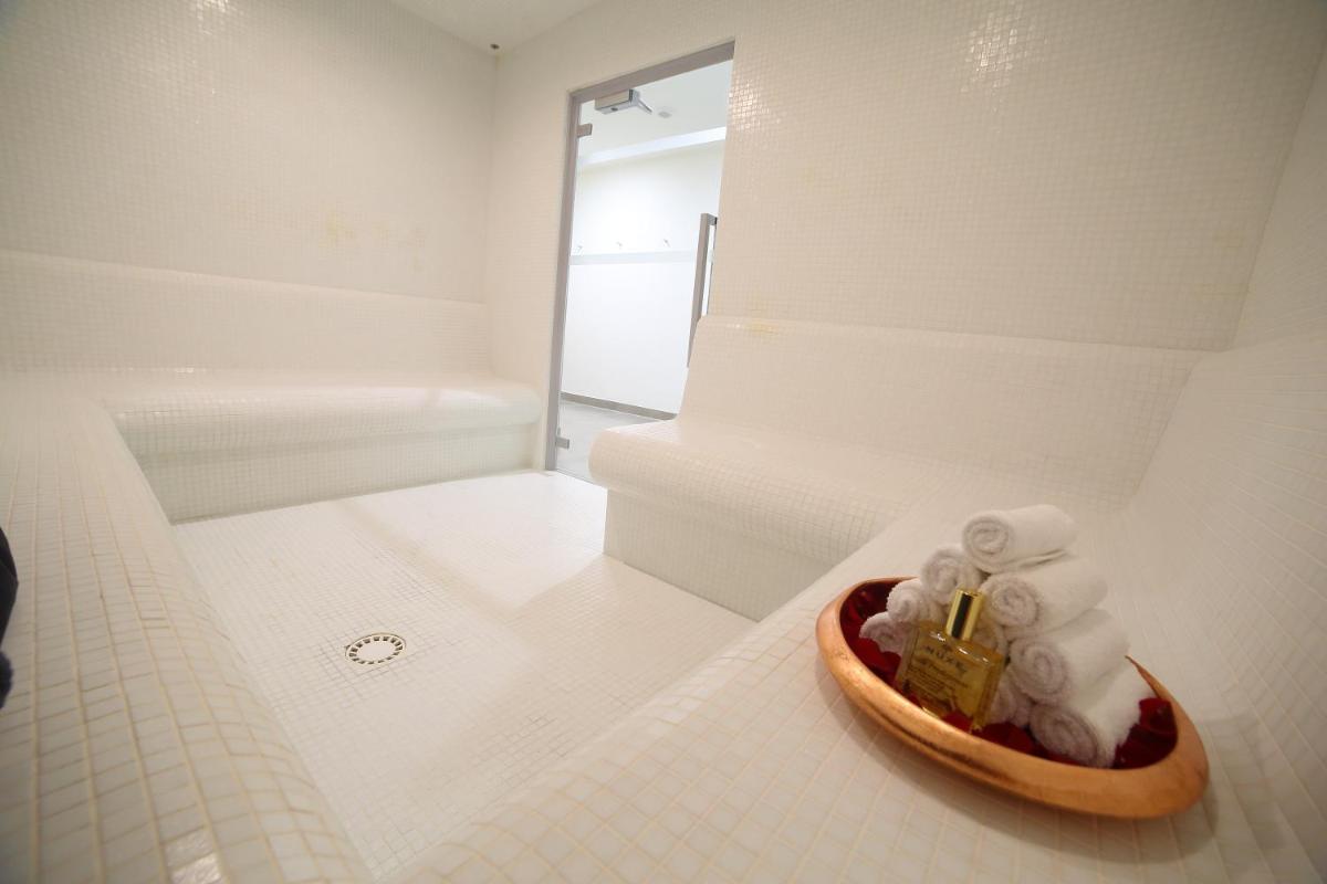 La salle de bains est pourvue d'un bol de serviettes et d'un miroir. dans l'établissement Hotel Plaza - site du Futuroscope, à Chasseneuil-du-Poitou