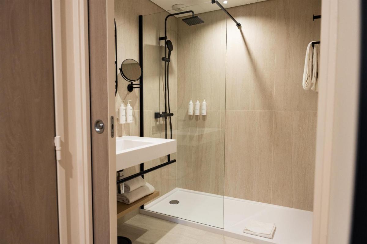 une salle de bain avec douche et lavabo dans l'établissement Le Relais de La Malmaison, a member of Radisson Individuals, à Rueil-Malmaison