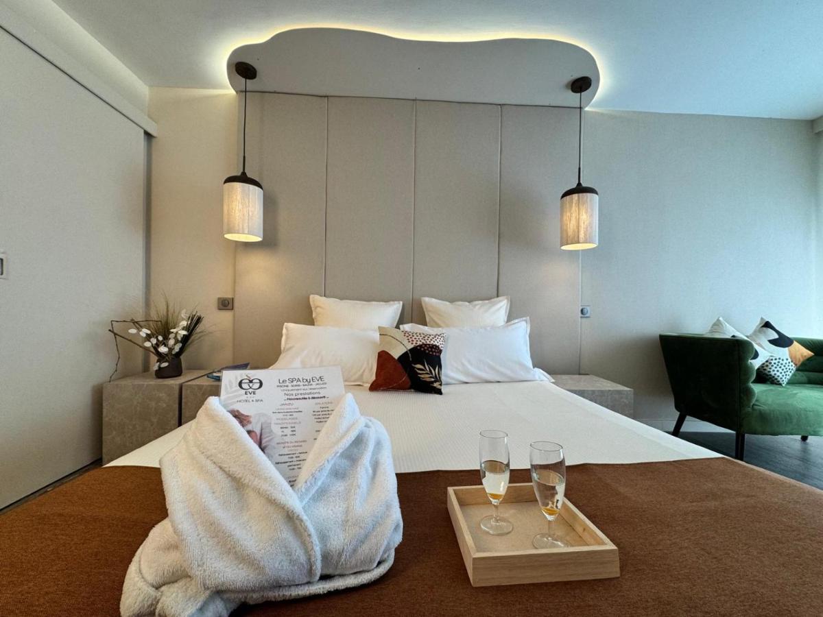 une chambre d'hôtel avec un lit avec deux verres de vin dans l'établissement Hôtel Eve Cap d'agde Village Naturiste, au Cap d'Agde