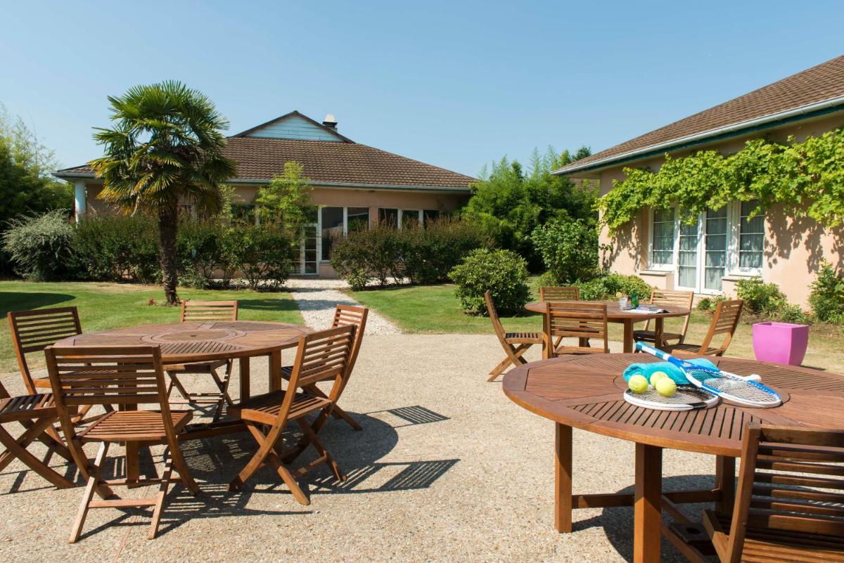 d'une terrasse avec deux tables et des chaises en bois. dans l'établissement Espace Leonard De Vinci, à Lisses