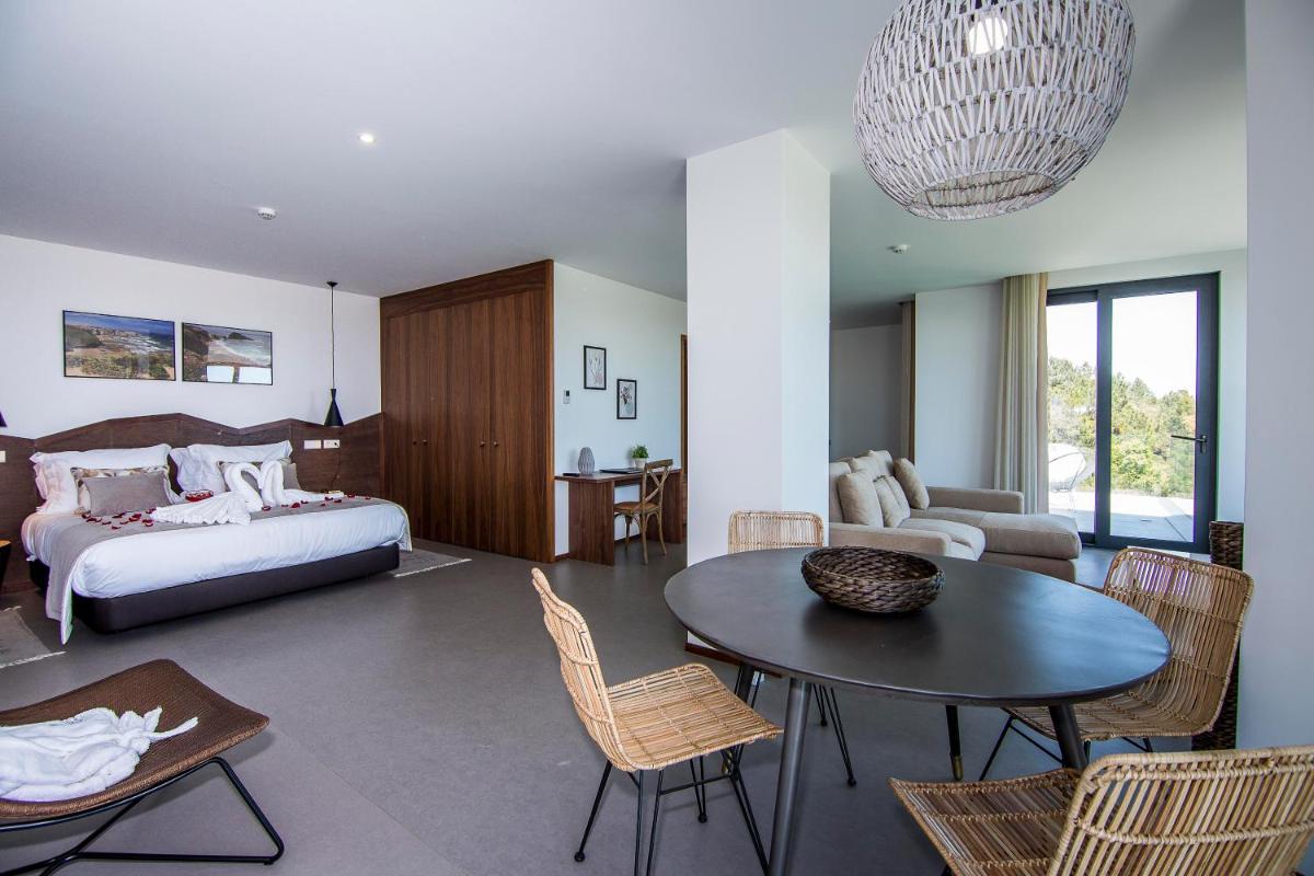 um quarto com uma cama, uma mesa e cadeiras em Enigma - Nature & Water Hotel em São Teotónio mais 70 fotografias