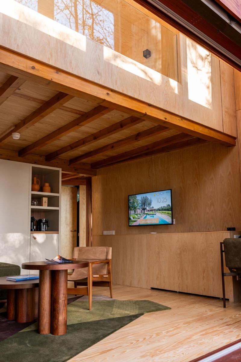 uma sala de estar com uma mesa e uma TV na parede em Torre de Gomariz Wine & Spa Hotel em Braga