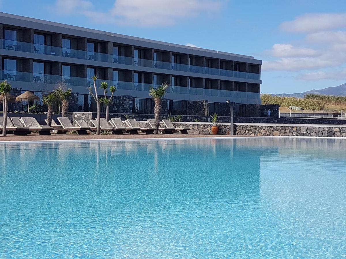 um hotel com piscina em frente a um prédio em Pedras do Mar Resort & Spa em Fenais da Luz