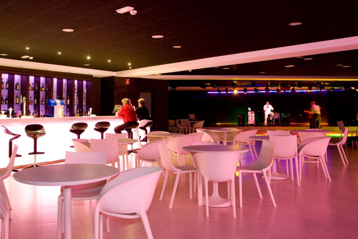 Un restaurante con mesas y sillas blancas y un bar. en R2 Romantic Fantasia Suites - Adults Only, en Tarajalejo 29 fotos más