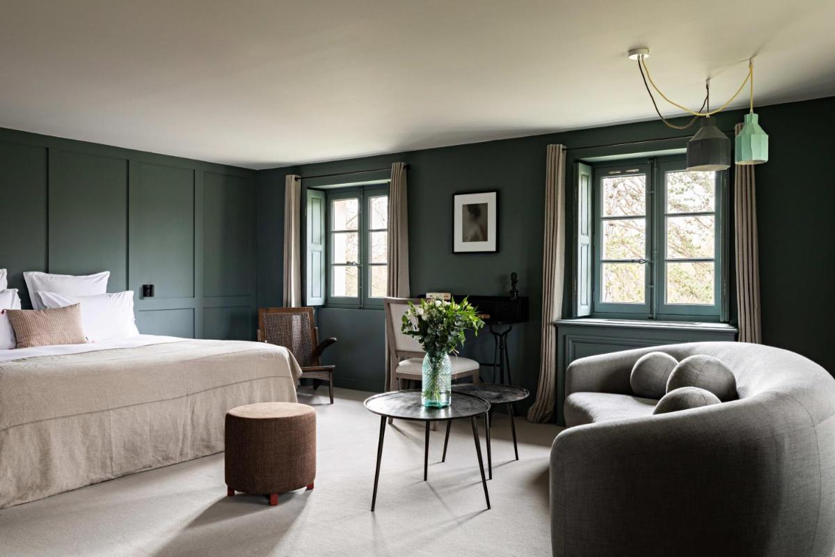 une chambre avec des murs verts, un lit et un canapé dans l'établissement Domaine de Primard - Fontenille Collection, à Guainville 73 autres photos