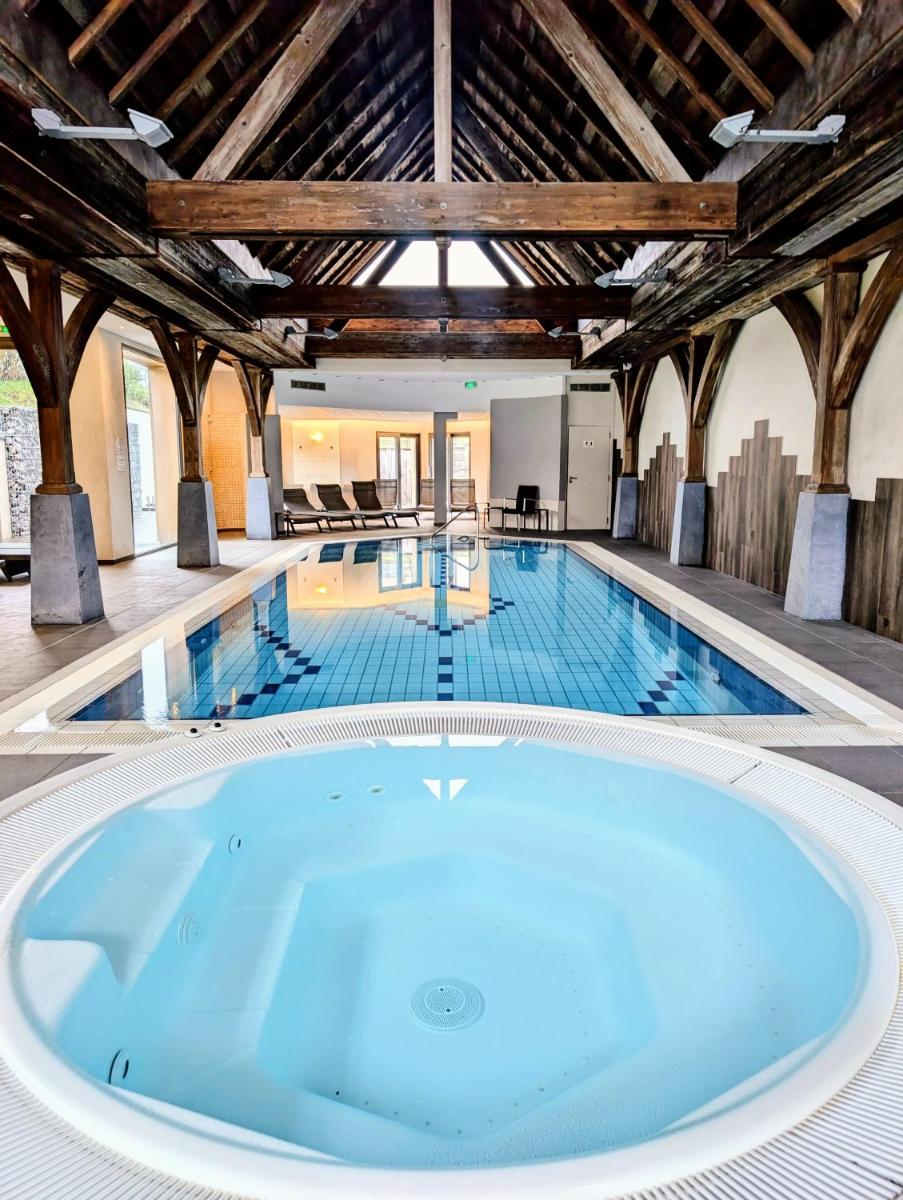 une grande piscine avec un grand bain dans l'établissement Logis Hotel Le Parc & Spa, à Saint-Hippolyte
