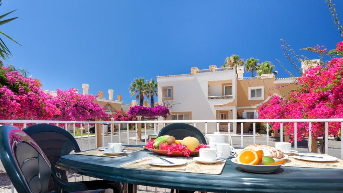uma mesa com uma tigela de frutas na varanda em Pestana Palm Gardens em Carvoeiro