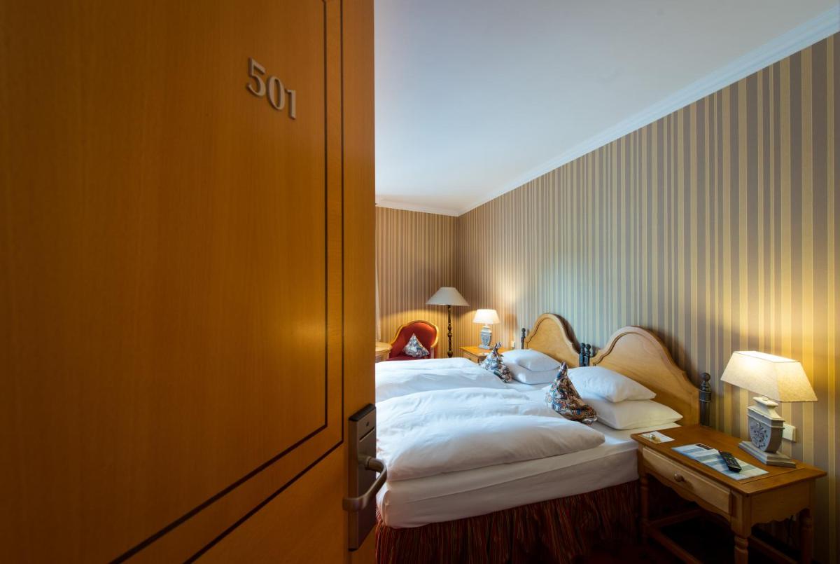 ein Hotelzimmer mit einem Bett und einem Tisch in der Unterkunft Landhaus Zu den Rothen Forellen in Ilsenburg + 25 Fotos